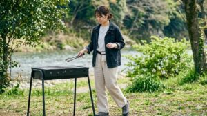 通気性の良いコットン素材のＴシャツと機能的なワイドパンツを組み合わせ、2026年のトレンドを意識した快適で動きやすいバーベキューファッション。笑顔で食材を準備する様子。